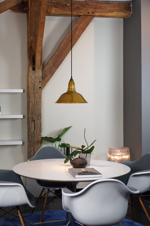 goudkleurige lamp, boven wit ronde tafel met vitra kuipstoelen in lampenwinkel Rotterdam