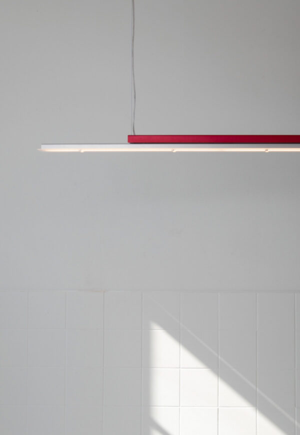 Array Level Light by Leo Krol: rood bovendeel, zilverkleurig armatuur.