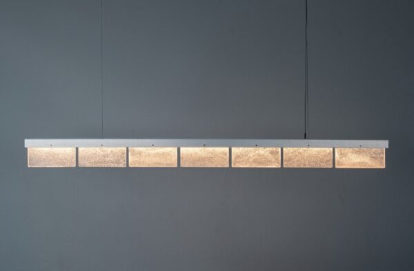 Zilverkleurige hanglamp ARRAY Slab Light Long by Leo Krol geproduceerd door David Derksen voor een donkere achtergrond