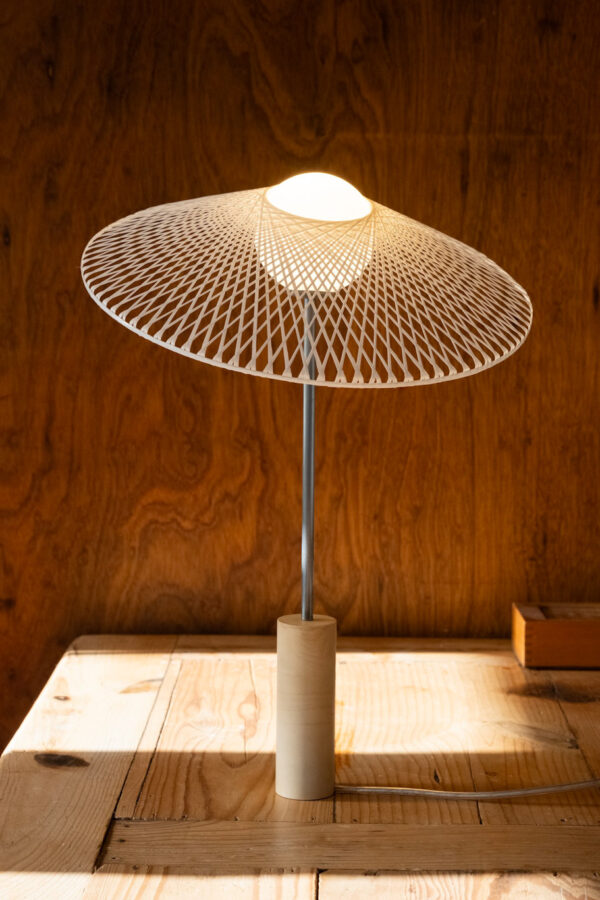 Schemerlamp Tilt Sand van Atelier Robotiq met Fiber kapje kleur Hazy Yellow een houten tafel