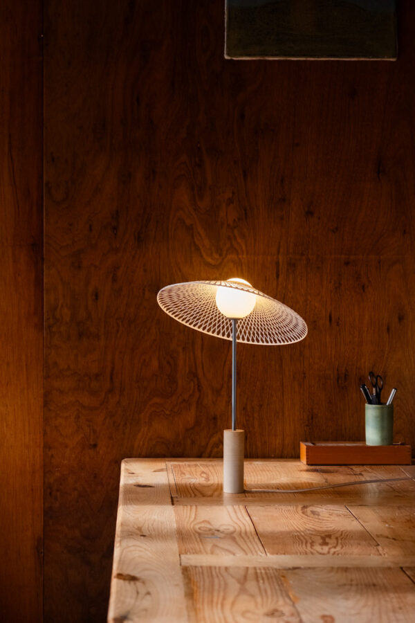 Schemerlamp Tilt Sand van Atelier Robotiq met Fiber kapje kleur Hazy Yellow op een houten tafel