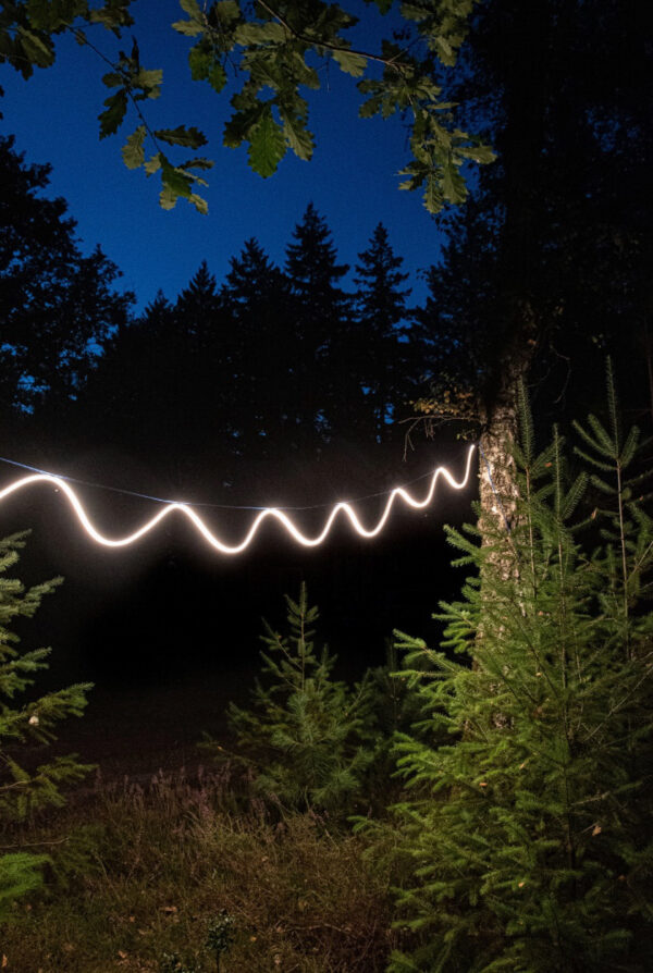 buitenverlichting Sine Light Outdoorin een tuin